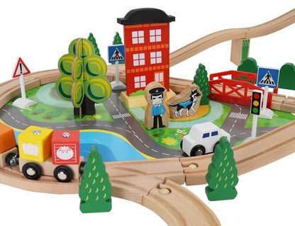 Tren Electric din Lemn Woody Train idealStore, 88 Elemente, Pista, Tren de Marfa si Pasageri, Masinuta, Copaci, Indicatoare Rutiere, Caine Politist, Figurine Persoane, Macara, Elemente Conectate prin Magneti
